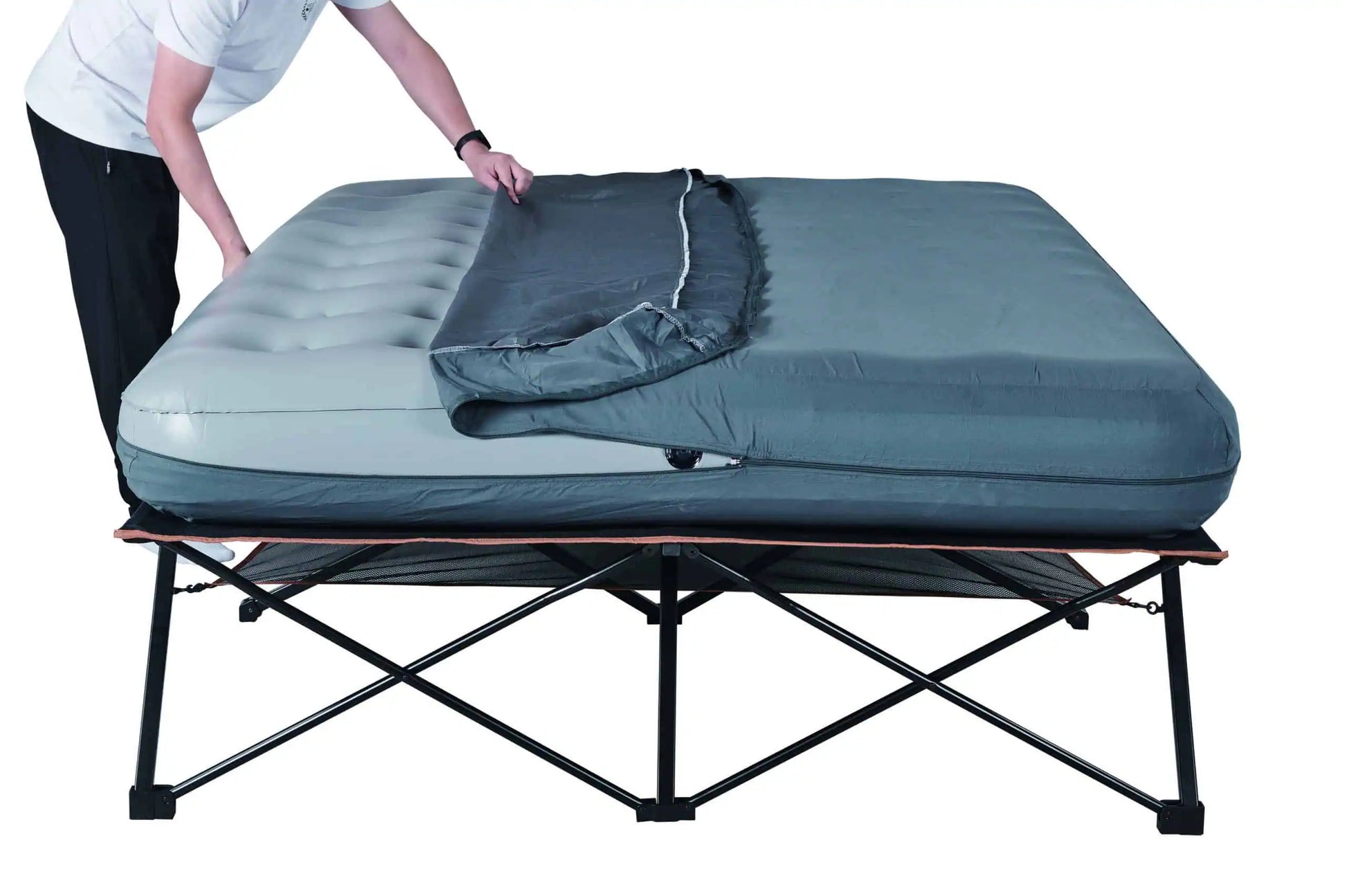 A person demonstrating how to zip the protective grey cover over the air mattress on the OZtrail Anywhere Queen Deluxe frame.