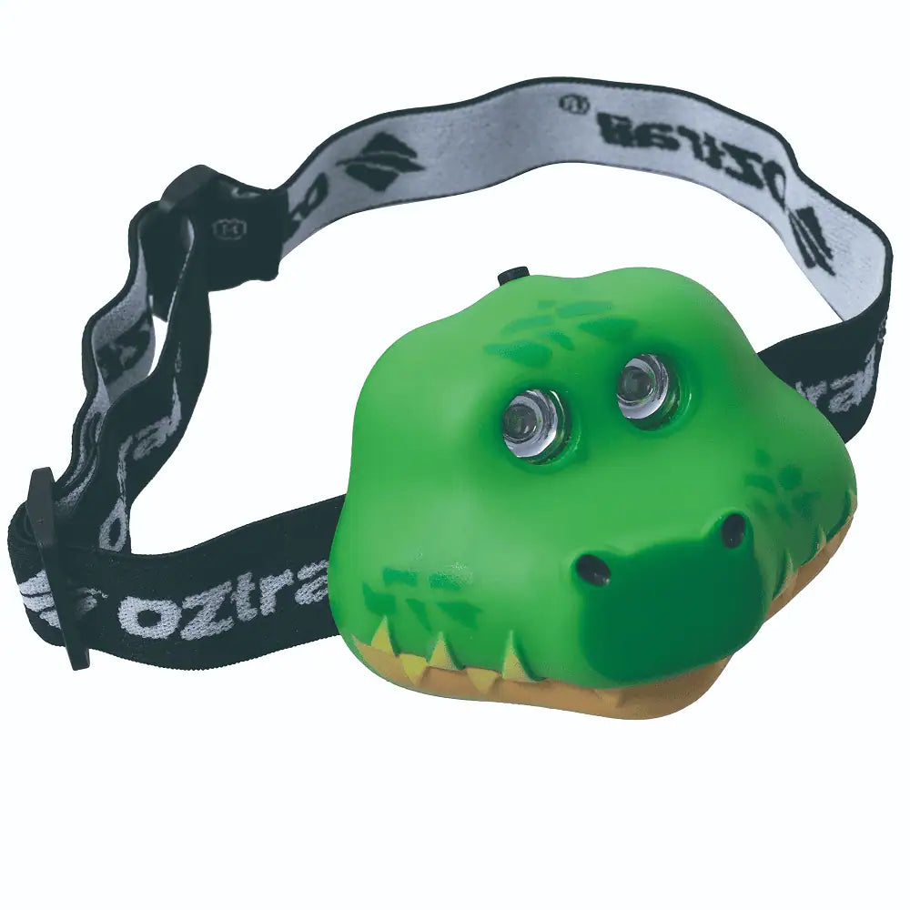  A green crocodile-shaped LED headlamp for children featuring a comfortable black and white OZtrail branded adjustable head strap.